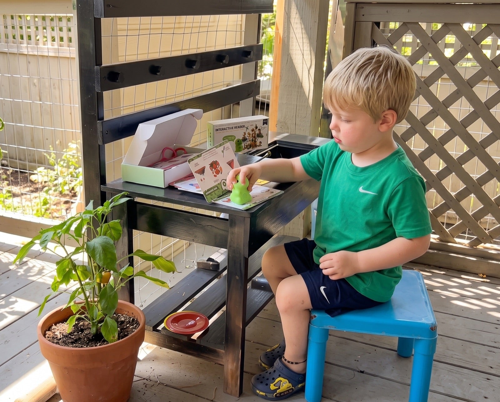 Young boy using PhonicsBuddy with phonics cards at his desk